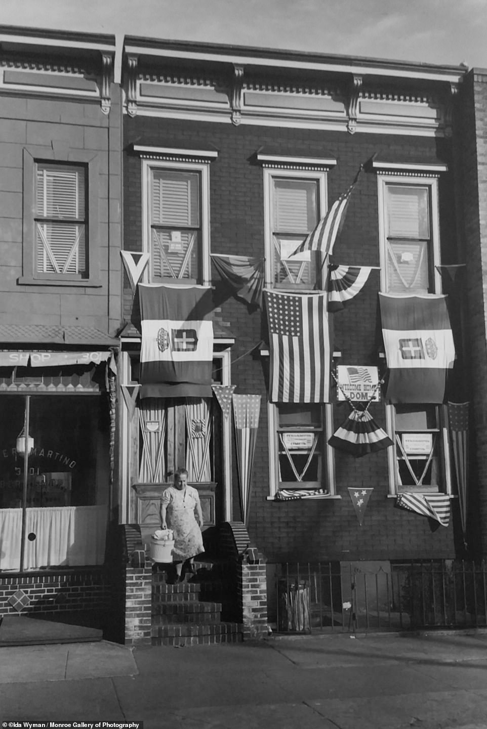 Taken in 1945, a mother in Brooklyn prepares the arrival of her son home from WWII with a sign that says 'Welcome Home Dom'.