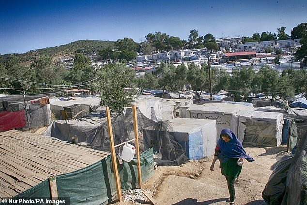 Moira has been under lockdown, allowing movement in small groups, since March 18. Pictured: An asylum seeker walking though the camp