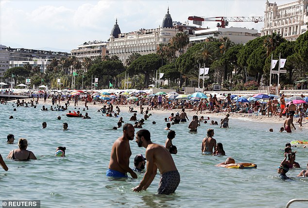 People enjoy a sunny afternoon at the beach of the Croisette in Cannes, France yesterday, where there are concerns over the arrival of British tourists