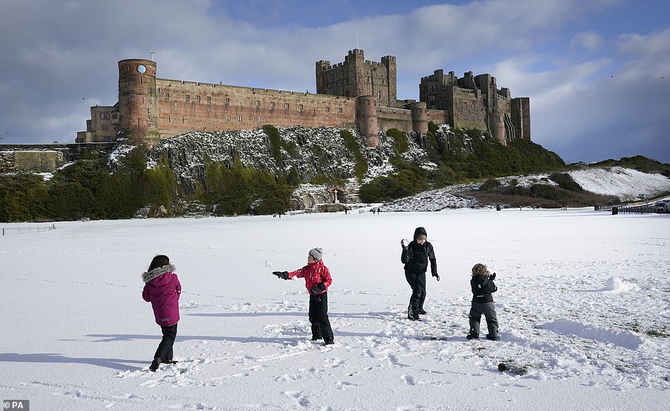 The Crompton family have a snow ball fight at Bamburgh Castle in Northumberland (left to right) Ottilie aged 9 , Reuben aged 6, mother Sian and Innis aged 3
