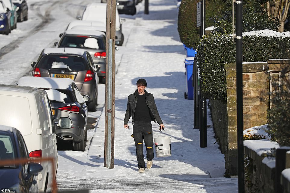 A man walks down a snow-covered street in Sheffield, as bitterly cold winds continue to grip much of the nation