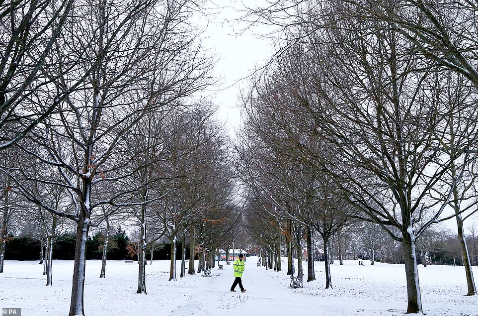 A man walks through Victoria Park in Ashford, Kent as Storm Darcy continues to lash Britain