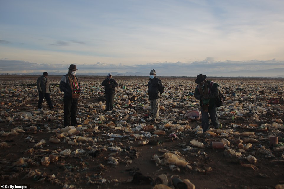 Local villagers Fidel Quispe, Cesar Condo, Felix Quiros, and Roberto Tarquiwalk among the plastic waste that has built up over several years