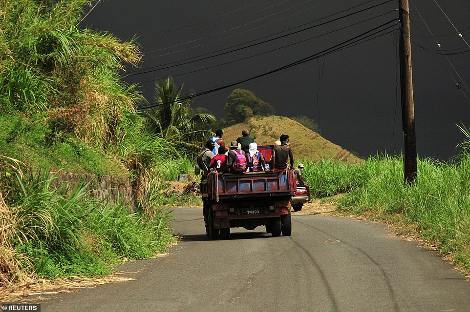 The sky was turned a moody grey colour as evacuees escape a red zone in village Rose Hall in the back of a farmer's truck amid warnings the eruptions could continue for several days and weeks