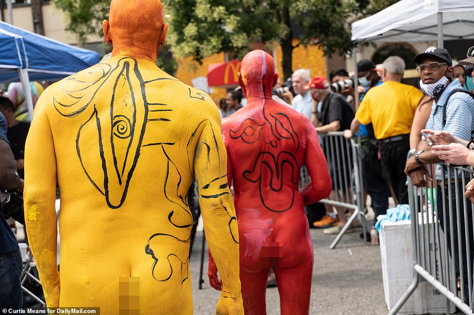 A yellow man closely follows a red man as the pair walk around Union Square Park in Manhattan