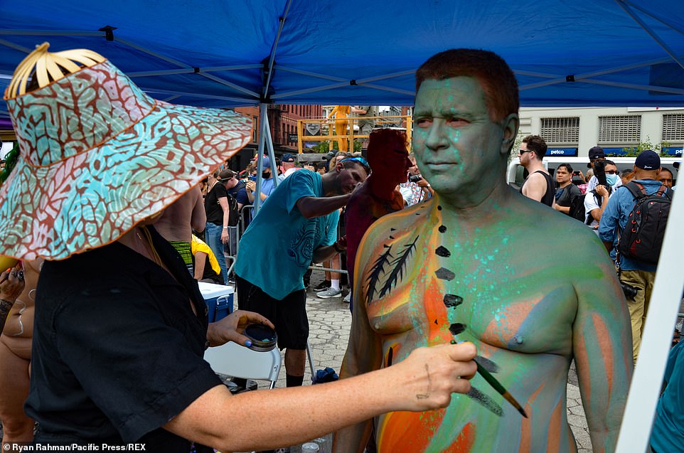 An ethereal landscape is painted onto the skin of one male participant