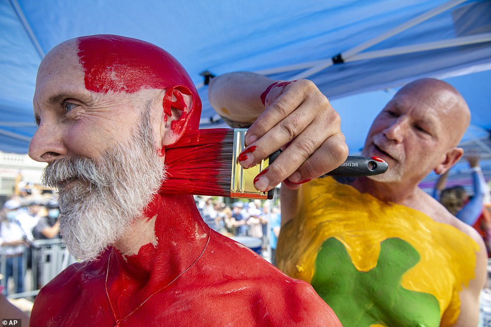 Bo Attwood, left, is painted by his partner Scott Ring, right, during the bodypainting event
