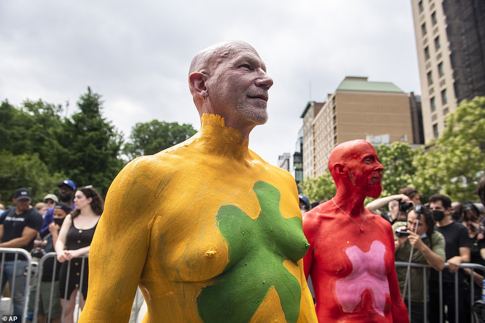 Scott Ring, left, and Bo Attwood, right, watch models get painted having been splashed in color themselves