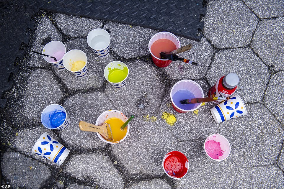 Cups of water and paint scatter the ground around the part where the event was taking place