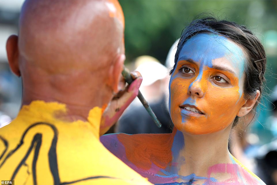 Body painting artist Leann (R) paints a model's face in Union Square at the 8th annual NYC National Body Painting Day