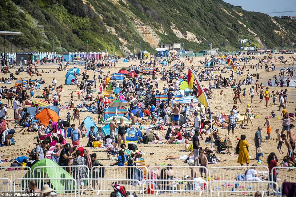 People enjoy the hot weather on beach at Bournemouth in Dorset with more summery conditions on the way