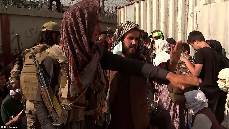 Taliban guards marshal crowds outside the airport where it is thought 6,500 people are now waiting to board flights