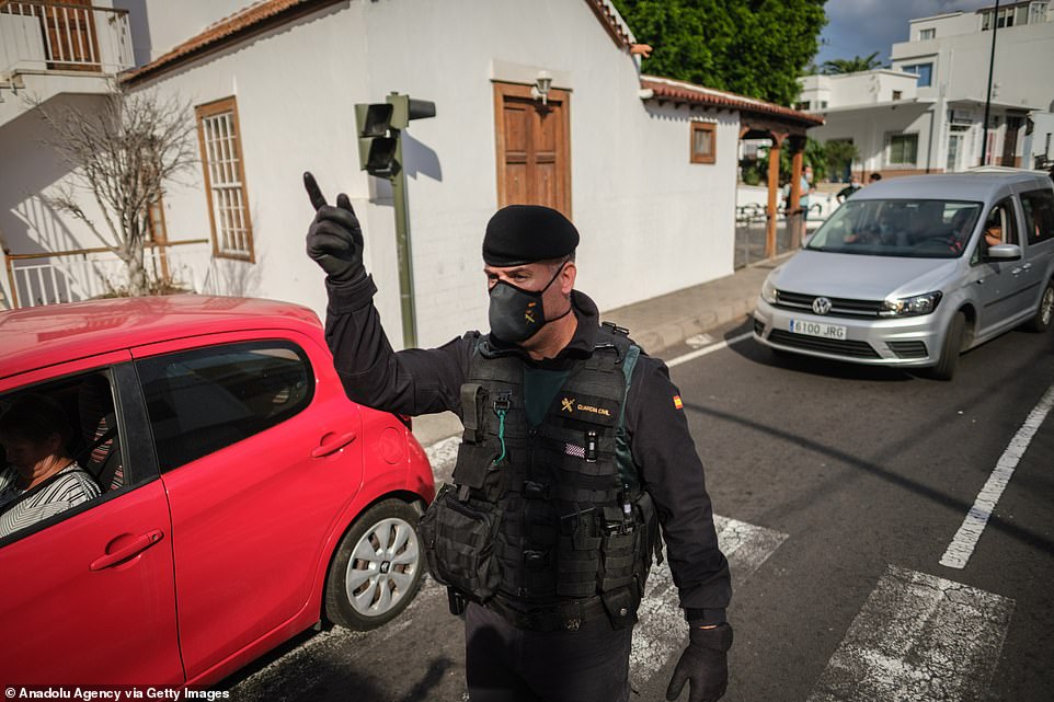 A policeman directs traffic in the town of Todoque as people evacuate in the face of a river of lava that is devouring homes