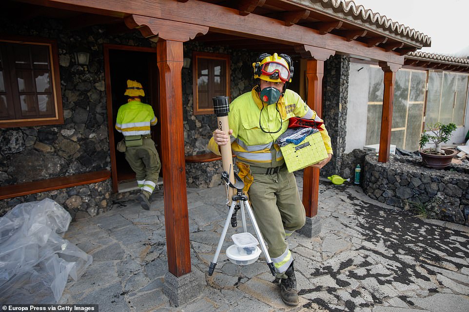 A fireman removes belongings from a home in the village of Todoque after people were told to evacuate as lava approached