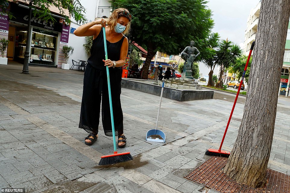 Nancy Ferrero sweeps ashes following the eruption of a volcano on the Island of La Palma