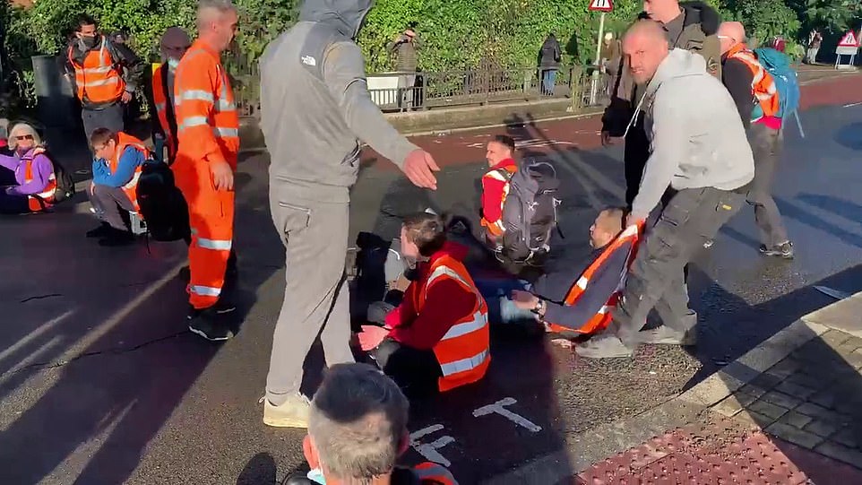 Insulate Britain protesters are dragged off the road at Wandsworth Bridge by angry motorists