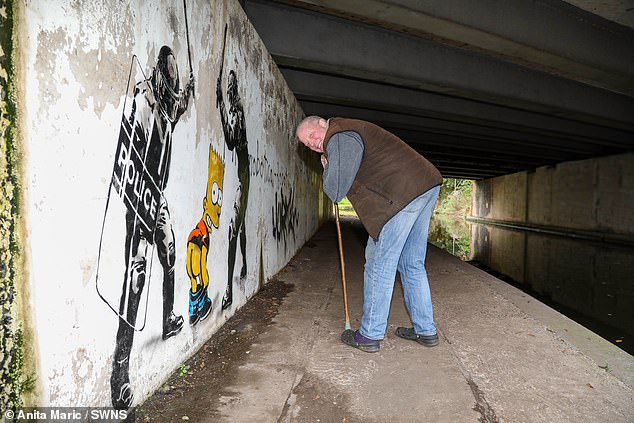 Darrell Meekcom, 55, posed next to the 'Banksy' mural in Worcester by bending over as the painted character of Bart Simpson is