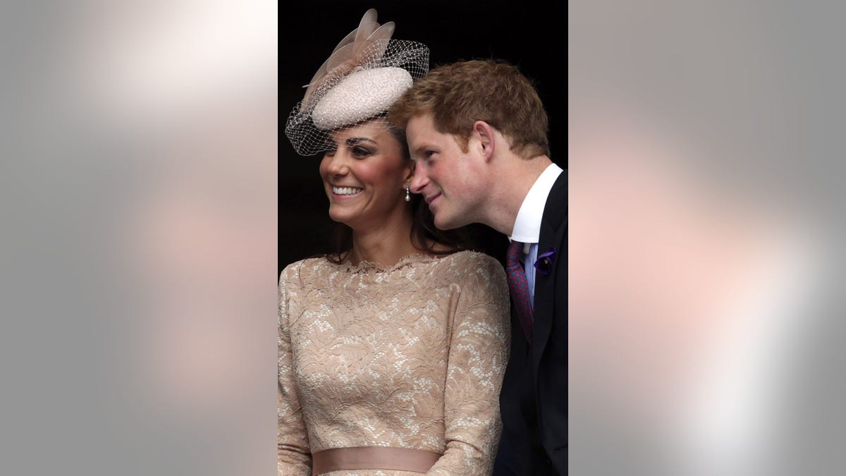 Prince Harry leaning next to Kate Middleton who is smiling
