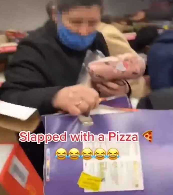 The woman is slapped round the face with two pizzas
