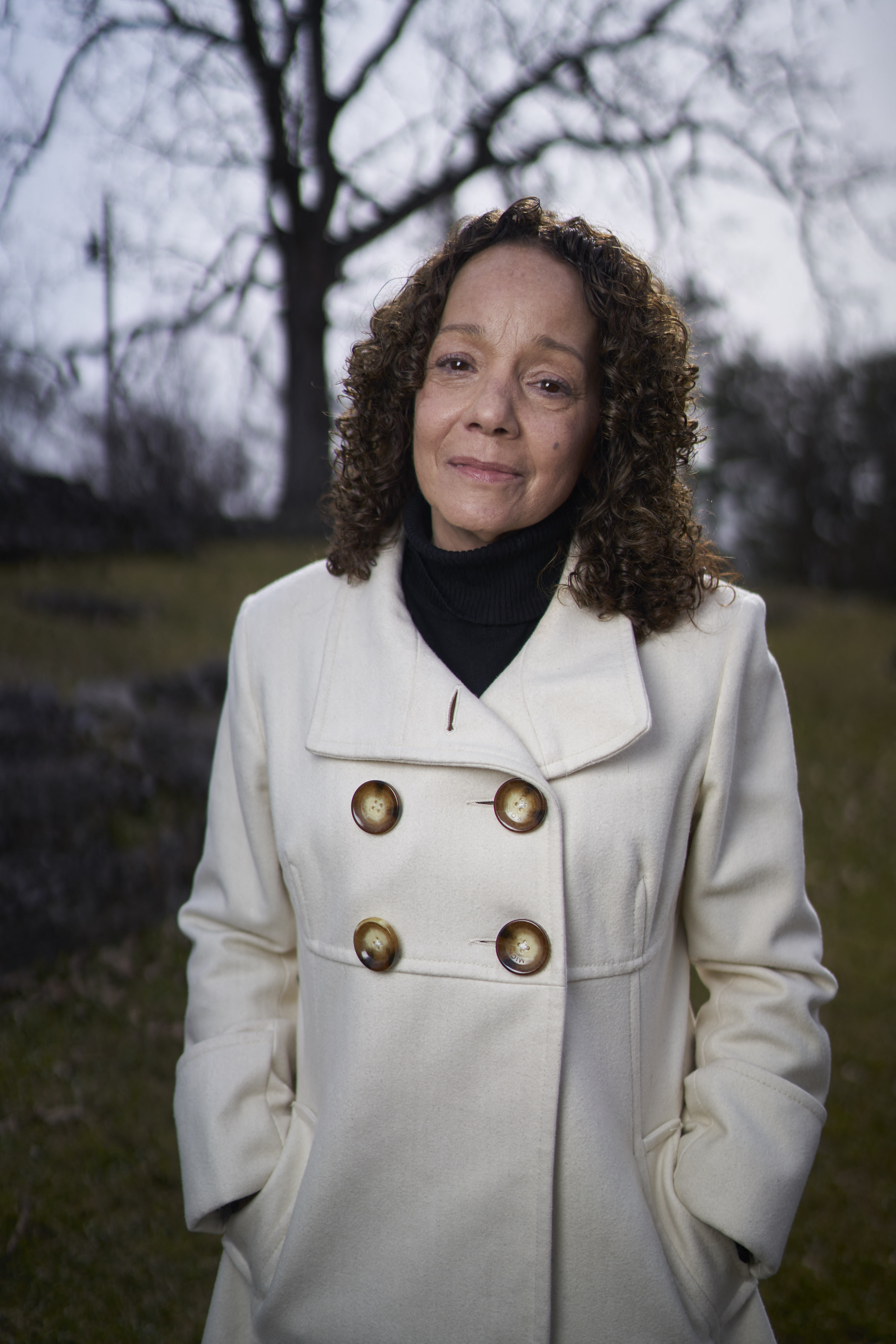 Mariah Carey's sister Alison Carey posing in a white button-up jacket in a past photoshoot